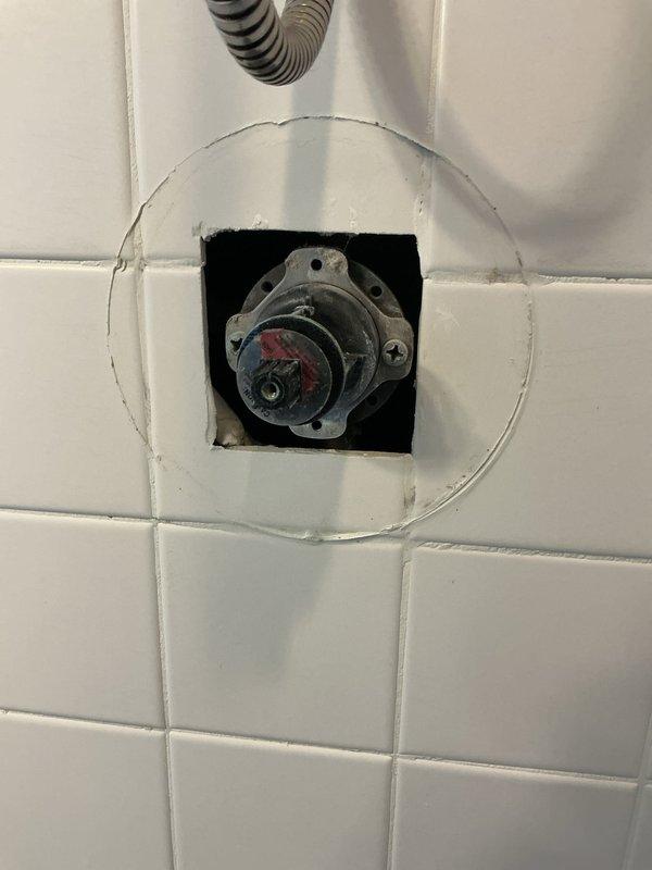 Responded to upstairs main bedroom shower malfunction in 25-year-old home. Upon inspection, identified faulty Kohler temperature control valve that had been experiencing operational issues for approximately one week. Removed chrome trim plate and handle assembly from white subway tile wall to access valve body. Disassembled existing single-lever thermostatic mixing valve, revealing worn internal cartridge components causing improper temperature regulation and flow control. Replaced defective valve cartridge with manufacturer-approved replacement part, ensuring proper alignment of hot and cold water indicators. Reassembled fixture, secured mounting hardware, and reinstalled chrome trim plate and lever handle. Tested shower operation through full range of motion, verified appropriate water temperature mixing, and confirmed adequate flow rate. System restored to proper working condition with no leaks detected at valve body or trim connections.