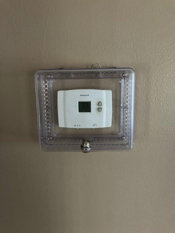 Completed full system replacement estimate for residential HVAC equipment. Evaluated existing outdoor condenser unit positioned against exterior wall and assessed interior Honeywell thermostat with protective cover for replacement specifications. Documented current system configuration and equipment condition to provide comprehensive quote for complete heating and cooling system installation at two properties scheduled for same appointment.