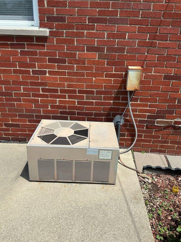 Provided replacement estimate for 28-year-old air conditioning and natural gas furnace system located in basement. Current equipment operational but nearing end of service life. Evaluated existing outdoor condenser unit positioned on concrete pad against exterior brick wall and assessed electrical service connections and refrigerant line routing for replacement specifications.