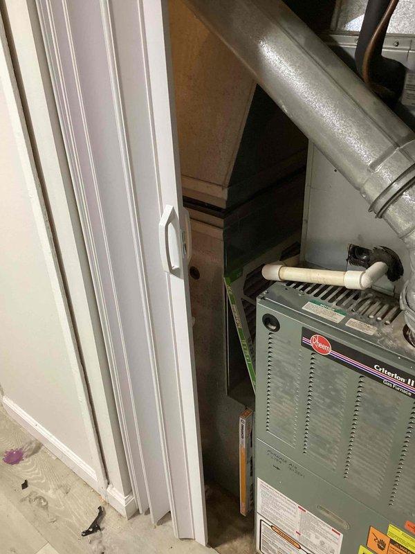 Performed comprehensive assessment of 23-year-old residential AC system with non-operational condenser unit. Evaluated Rheem furnace installation in basement mechanical space and inspected exterior condenser location at building perimeter near electrical meter and window well. Documented equipment condition, ductwork configuration, and system layout to provide full system replacement estimate due to condenser failure and age of existing equipment.