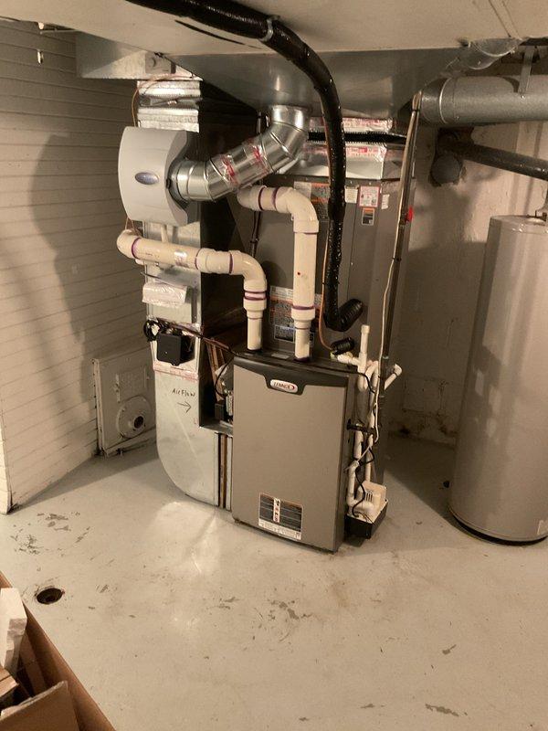 Completed installation of 3.5-ton air conditioning system with matching evaporator coil in right side yard location. Installed Lennox furnace with integrated coil assembly in basement mechanical room, established proper condensate drainage using PVC piping, and connected all ductwork including supply and return air plenums. Verified all refrigerant line connections, electrical wiring to outdoor condenser unit, and reconnected existing humidifier to new system for full operational functionality.