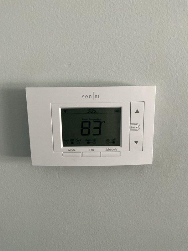 Responded to no cooling complaint on 4-year-old R-410A air conditioning system located in basement. Upon arrival, found Sensi thermostat displaying 83°F ambient temperature with no cooling mode available. Performed diagnostic evaluation of thermostat wiring and communication between thermostat and CNPVP1A7LAAAAA condenser unit. Inspected equipment specification label confirming R-410A refrigerant system manufactured in 2021 with 450 PSIG design pressure rating. Conducted full system inspection as requested, evaluating electrical connections, refrigerant circuit integrity, and control board functionality. Identified thermostat configuration issue preventing cooling mode activation. Restored proper thermostat settings and verified system communication. Cycled unit through complete operational test, confirming cooling mode now accessible and system responding appropriately to temperature calls. System returned to normal operation with all safety controls functioning properly.
