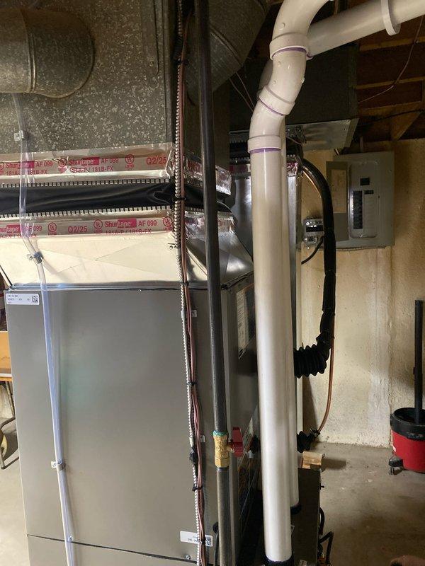 Completed full HVAC system installation including 70,000 BTU furnace and 2.5 ton rear-discharge air conditioning unit. Installed new thermostat, humidifier, and liner system with proper venting configuration. Coordinated mechanical permit and arranged for electrical reconnection work. Installed condensate pump with 500-micron evacuation performed on refrigerant lines. Routed PVC drainage piping from indoor unit through basement ceiling and exterior wall with proper pitch and support. Mounted outdoor condenser unit on pad with appropriate clearances. Verified AHRI certification match for system components. System tested and operational, qualifying for applicable utility rebates.