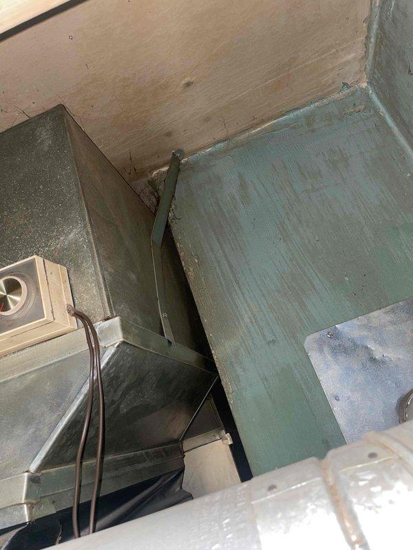Provided replacement estimate for 25-year-old central air conditioning system located on west side of residence. Inspected existing outdoor condenser unit and indoor components, documenting current equipment condition through photos of aged HVAC ductwork and interior mechanical spaces showing weathered metal surfaces with oxidation. No immediate operational issues reported; estimate prepared for complete system replacement due to equipment age.