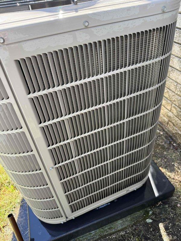 Completed comprehensive Gold AC inspection on 13-year-old residential air conditioning system with basement-located air handler. Performed electrical diagnostics on outdoor condenser unit using clamp meter to verify proper amperage draw and system performance. Inspected condenser coil fins, confirmed unit operation, and verified adequate clearance around equipment, noting minor weathering consistent with age but overall functional condition of system.