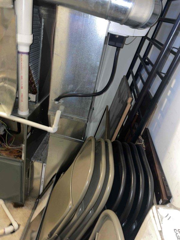 Conducted comprehensive assessment of basement air conditioning system experiencing freeze-up conditions. Evaluated existing HVAC equipment installation, including air handler, ductwork configuration, and associated components mounted in utility area. Documented current system layout featuring flexible ductwork, metallic supply ducts, and PVC drainage lines to provide accurate replacement estimate addressing the freezing issue and system performance concerns.