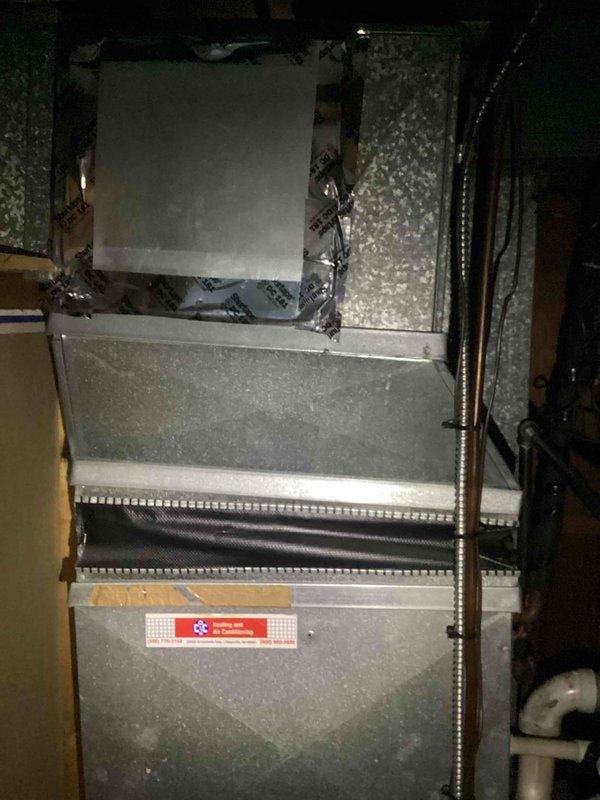 Responded to service call for air conditioning system not turning on at residential property. Performed diagnostic evaluation of basement-mounted HVAC system including gray metal air handler unit with coil assembly and associated ductwork. Provided estimate for complete system replacement due to equipment age and operational failure, documenting existing installation configuration with flexible metallic ductwork, vertical piping, and current air handler positioning for replacement specifications.