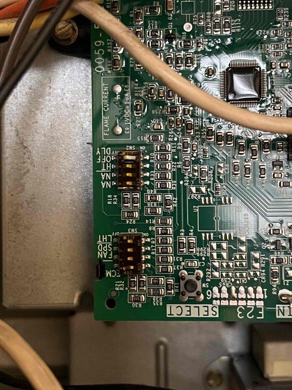 Responded to callback for ongoing air conditioning issue on 10+ year old system. Inspected control board and wiring connections following previous service visits by other technicians. Documented flame sensor circuit board and low-voltage wiring terminations with wire identification labels intact. Verified proper wire routing and connections at control board including R, Y1, and T1 terminals with secure wire nut connections. Provided technical assessment of system control components and clarified previous diagnostic findings to resolve conflicting repair recommendations.