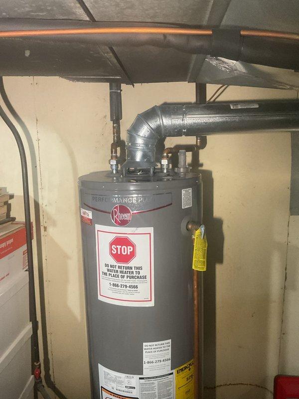 Provided estimate for replacement of non-functioning natural draft water heater with new 40-gallon short Rheem unit. Assessed existing installation in basement utility area, noting natural draft venting configuration and corroded copper supply piping. Customer approved Gold Plan coverage for installation of replacement tank-style water heater to restore domestic hot water service to residence.