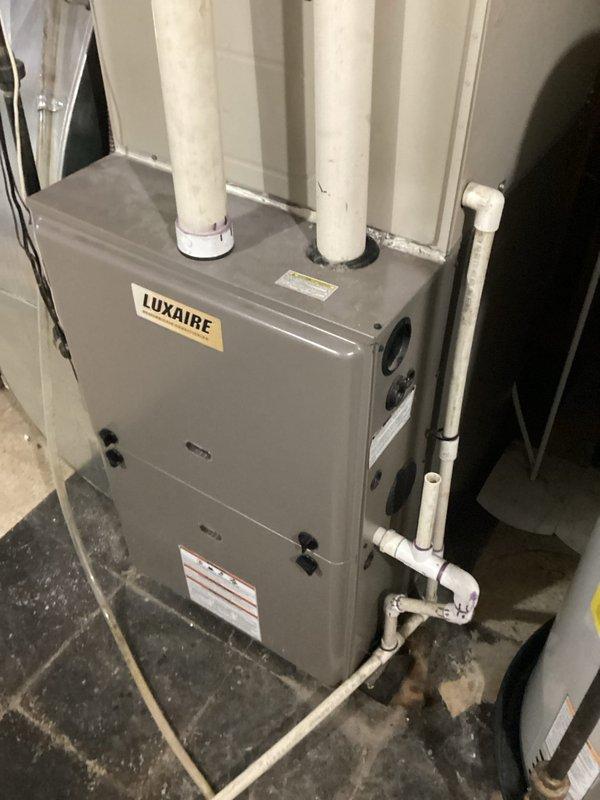 Completed comprehensive inspection of residential air conditioning system over 15 years old located at side of house with furnace in basement. Evaluated existing Luxaire furnace unit and associated HVAC components including Aprilaire automatic humidifier mounted on ductwork plenum. Assessed overall system condition, operational status, and equipment age to provide replacement estimate for aging AC unit and related mechanical systems.
