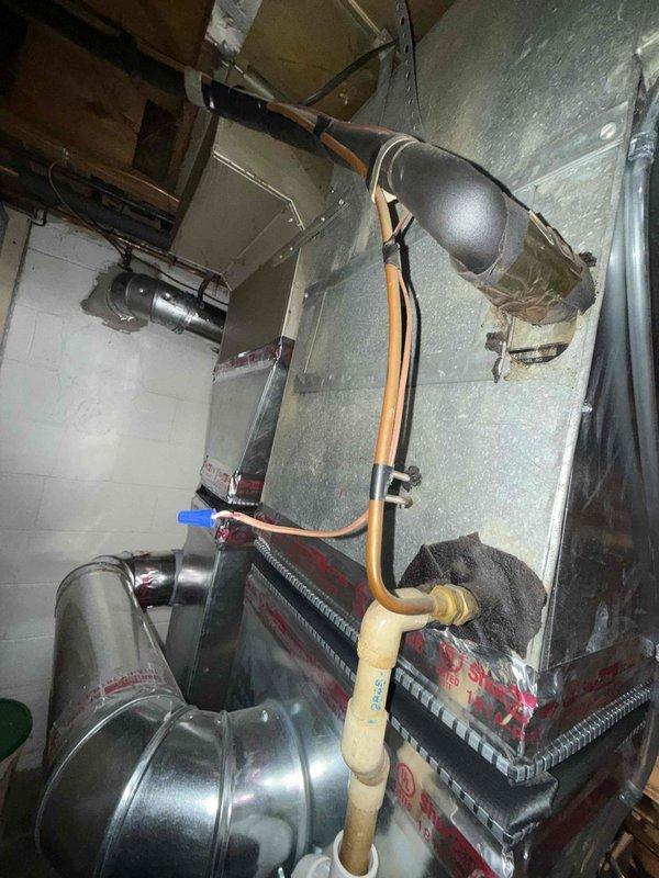 Responded to no cooling call on 25-year-old air conditioning system with fan operation but no cooling affecting entire residence. Upon arrival, performed diagnostic testing of outdoor unit and indoor air handler components. Utilized digital multimeter to test electrical connections, capacitor values, and control board functionality at the air handler. Measured voltage readings at control board showing 27.1V on low voltage circuit. Inspected refrigerant lines, ductwork connections, and all electrical wiring at indoor unit. Documented equipment condition with photographs showing air handler installation, ductwork configuration, and diagnostic measurements. Based on age of system and diagnostic findings, provided customer with assessment of unit condition and repair options. System requires further evaluation of outdoor condensing unit components including compressor operation, capacitor condition, and refrigerant charge to determine root cause of cooling failure.
