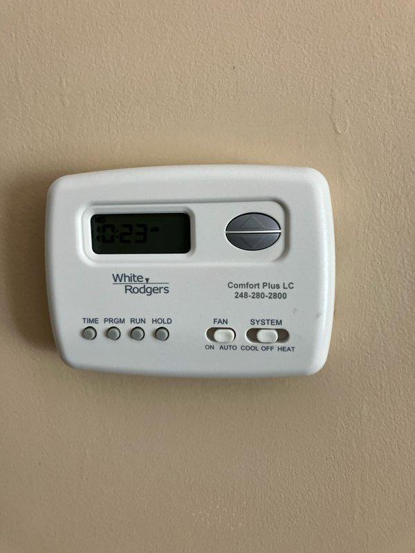 Conducted on-site evaluation for replacement estimate of twenty-year-old air conditioning system located outside downstairs front of residence. Documented existing HVAC equipment including Bryant furnace with gas piping and White Rodgers programmable thermostat. Captured photographic documentation of current system components to assess compatibility requirements and provide accurate replacement specifications for new air conditioner installation.