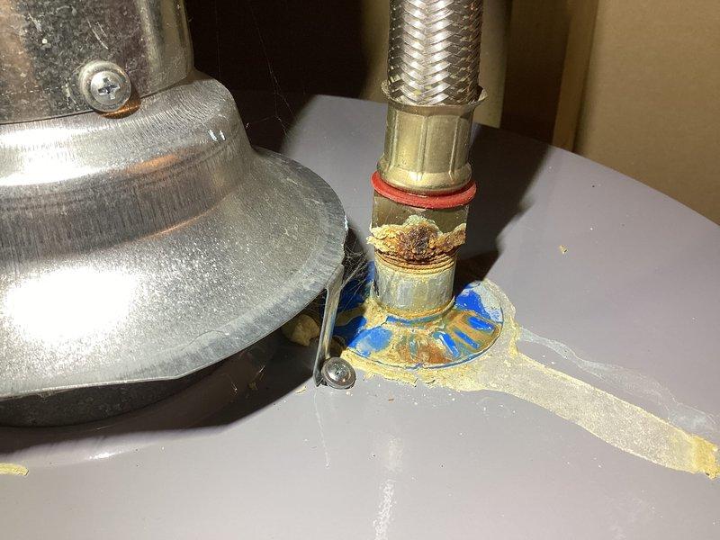 Completed comprehensive Gold AC inspection on 25-year-old residential air conditioning system with air handler located in basement and dual outdoor condenser units. Performed full system evaluation including visual inspection of both outdoor condensers, which showed accumulation of debris and organic material on surrounding ground area and unit surfaces. Inspected basement mechanical equipment and plumbing connections, noting mineral deposits and discoloration around water heater pan area indicating previous moisture issues. Documented system condition through photographic records showing outdoor unit placement in landscaped area with adequate clearance and indoor mechanical components. System operational at time of inspection with homeowner present to discuss findings and maintenance recommendations for aging equipment.