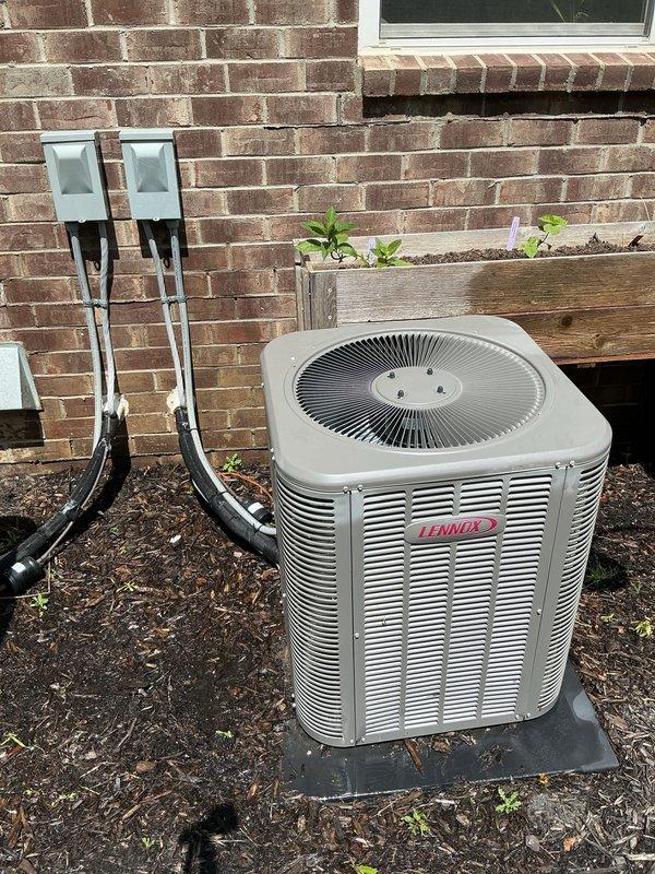 Completed comprehensive Gold AC Inspection on a 6-year-old Lennox air conditioning system with air handler located in basement. Performed full system evaluation including condenser unit inspection, verified proper operation of outdoor unit with fan grille and louvered cabinet panels, checked electrical connections and disconnect boxes mounted on exterior wall, confirmed unit is properly mounted on concrete pad with adequate clearance, and verified surrounding area is clear of debris with mulch landscaping maintained appropriately. System is operating as designed with no deficiencies noted during inspection.