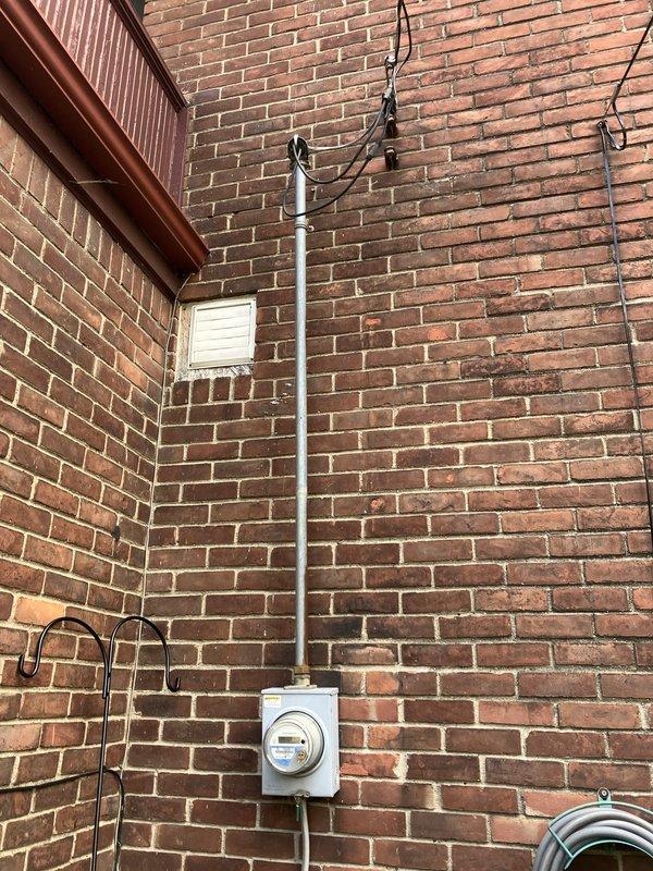 Completed comprehensive estimate for full replacement of existing space pack HVAC system located in attic. Current unit has exceeded twenty-year service life and requires complete replacement. Assessed attic-mounted equipment accessibility and confirmed ladder access required for installation. Evaluated existing outdoor condensing unit positioned on concrete pad adjacent to building exterior, noting electrical disconnect and conduit routing along brick wall. Inspected electrical service connection point at meter location to verify adequate power supply for new system installation. Documented current system configuration and provided homeowner with replacement options and upgrade recommendations for improved efficiency and performance.