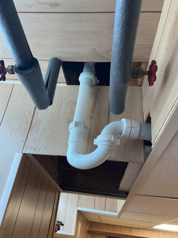 Responded to leaking tub faucet causing water intrusion from bathroom into basement area below. Upon arrival, confirmed active leak with water pooling in pan beneath affected area. Accessed plumbing cavity through wall opening to expose vertical supply lines and drain configuration. Inspection revealed significant water damage to surrounding materials, including mold growth on wall surfaces and deterioration of structural components from prolonged moisture exposure. Identified compromised faucet valve assembly as primary leak source affecting copper supply lines serving tub fixtures. Removed defective faucet components and assessed condition of existing plumbing connections within wall cavity. Addressed corroded pipe fittings and replaced faulty valve mechanisms to restore proper water flow control. Verified all supply line connections for secure sealing and tested system under pressure to confirm leak elimination. Documented extensive water damage present in wall cavity and basement c