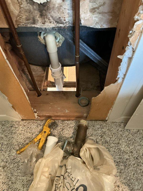 Responded to leaking tub faucet causing water intrusion from bathroom into basement area below. Upon arrival, confirmed active leak with water pooling in pan beneath affected area. Accessed plumbing cavity through wall opening to expose vertical supply lines and drain configuration. Inspection revealed significant water damage to surrounding materials, including mold growth on wall surfaces and deterioration of structural components from prolonged moisture exposure. Identified compromised faucet valve assembly as primary leak source affecting copper supply lines serving tub fixtures. Removed defective faucet components and assessed condition of existing plumbing connections within wall cavity. Addressed corroded pipe fittings and replaced faulty valve mechanisms to restore proper water flow control. Verified all supply line connections for secure sealing and tested system under pressure to confirm leak elimination. Documented extensive water damage present in wall cavity and basement c