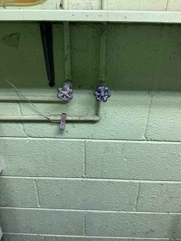 Replaced both hot and cold water supply valves serving the washing machine in basement utility area. The original valves, which were likely original to the 1963 home construction, had begun to fail and required immediate replacement to restore proper water supply control. Installed new quarter-turn ball valves with cross-handle operation to provide reliable shutoff capability and prevent potential water damage from leaking or malfunctioning valves.