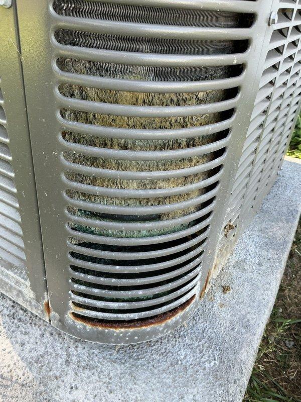 Responded to no cooling complaint on 4-year-old residential air conditioning system. Upon arrival, verified thermostat set to cooling mode at 73°F with no cold air delivery throughout home. Proceeded to outdoor condensing unit for inspection. Found condenser coil heavily restricted with dirt, dust, and debris accumulation between fins, significantly reducing airflow and heat transfer capability. Noted beginning stages of corrosion at base of unit with minor rust spots present on cabinet. Restricted airflow was causing inadequate heat rejection and preventing proper system operation. Cleaned condenser coil thoroughly to restore proper airflow and system efficiency. Verified unit operation after cleaning with proper cooling restored to residence. System covered under existing warranty.