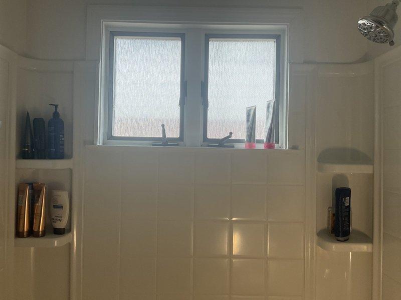 Completed on-site assessment for bathtub replacement in first floor bathroom of 1960s ranch-style home. Documented existing white subway-tiled shower/tub enclosure with chrome fixtures including temperature control valve, tub spout, and overhead shower head. Evaluated current bathtub condition, wall-mounted grab bar placement, and recessed shelf niches built into tile surround. Photographed existing plumbing fixtures, tile work, and bathroom configuration to provide accurate estimate for tub removal and replacement project.