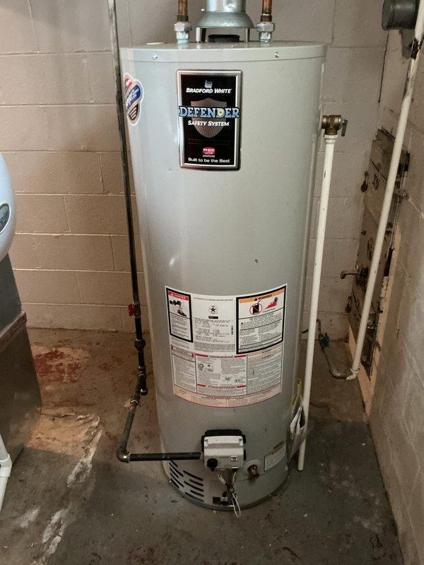Completed comprehensive Gold AC Inspection on a 3-year-old residential air conditioning system with air handler located in basement. Performed full system evaluation including inspection of outdoor condensing unit on concrete pad, verified proper refrigerant line insulation, checked electrical connections and safety labels, and assessed Bradford White water heater in utility space. All equipment found operating normally with no immediate service needs identified, system components in good condition for age of unit.