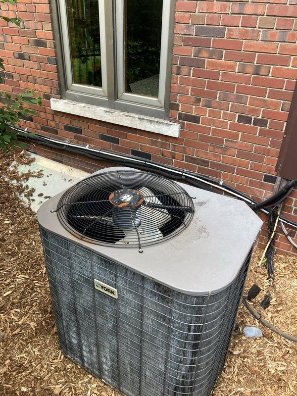 Completed estimate for cooling system replacement at residential property with large square footage exceeding 3000 sq.ft. Assessed existing York brand packaged air conditioning unit positioned on concrete pad adjacent to brick exterior wall. Unit evaluation included inspection of outdoor condenser with top-mounted fan assembly, refrigerant line routing along foundation, and overall system configuration for replacement planning purposes.