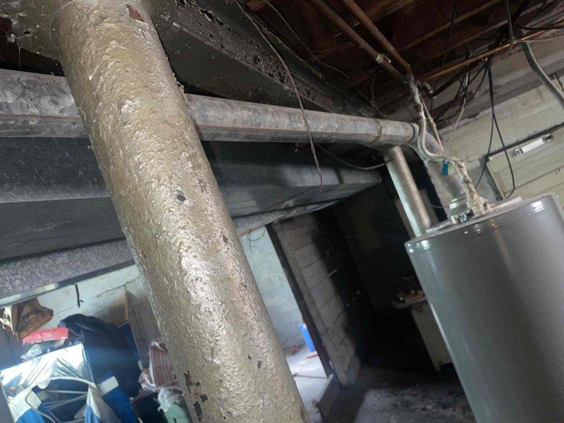 Completed estimate for furnace replacement in basement location. Existing 60-year-old furnace system evaluated with assessment of current ductwork, plenum connections, and venting configuration. Documented existing installation including aged insulated ductwork with visible wear, galvanized metal plenum with surface deterioration, and surrounding mechanical infrastructure to provide comprehensive replacement recommendations and specifications.