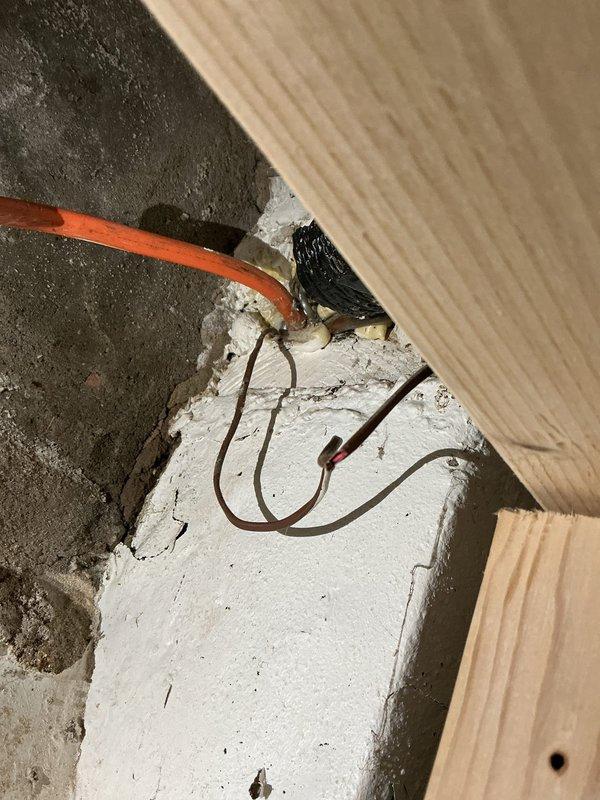 Responded to no cooling complaint on 2-year-old basement AC unit where fan operated but no cold air delivered through vents. Upon inspection, discovered compromised refrigerant line connections and improper electrical wiring at the air handler location. Repaired copper refrigerant piping penetrations, secured loose electrical connections with proper wire nuts, and verified system operation. Unit now cooling properly with adequate airflow through all registers.