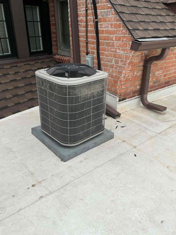 Completed comprehensive Gold AC inspection on 10+ year old single-unit residential air conditioning system with outdoor condensing unit and attic-located air handler. Performed full system evaluation including visual inspection of condenser unit positioned against exterior brick wall, verified operational status of all components, and documented equipment condition through photographic records. Noted vegetation encroachment around condenser unit requiring customer attention for optimal airflow and system efficiency.