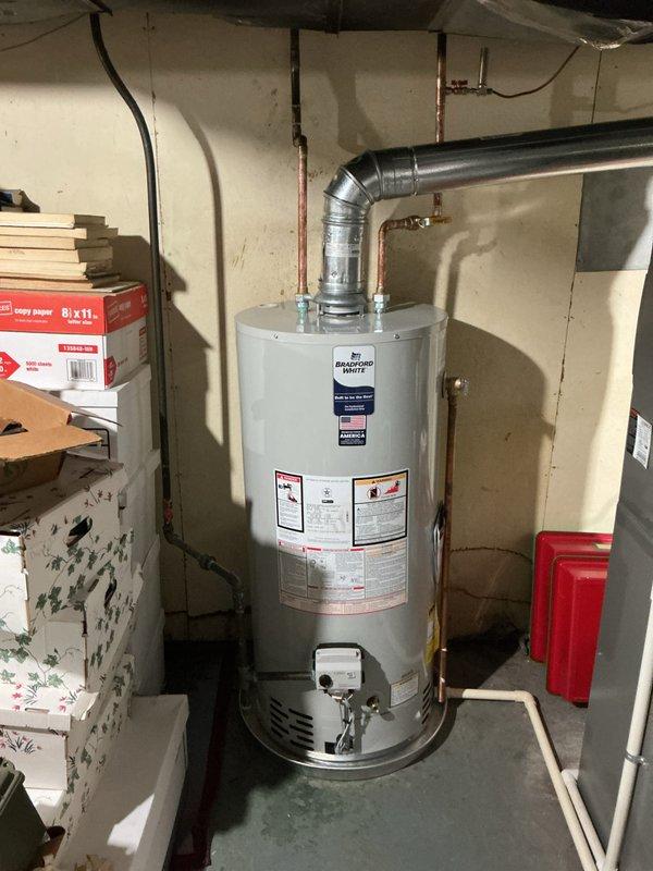 Installed 40-gallon short tanked water heater in basement utility area with proper B-vent exhaust system and drip pan for secondary protection. Connected copper supply lines with brass fittings and valves, established humidifier line integration, and verified all plumbing connections for proper operation. Unit mounted on concrete floor with metallic ductwork properly secured, all manufacturer specifications met, and system tested for safe operation.