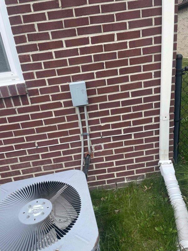 Provided comprehensive estimate for complete air conditioning system replacement at residential property with non-functional outdoor condensing unit over 10 years old located exterior to basement installation with natural gas furnace. Assessed existing equipment condition including weathered condenser unit with fan assembly, electrical disconnect box, refrigerant line sets, and condensate drainage system mounted against brick exterior wall. Prepared replacement specifications for new cooling system compatible with existing natural gas heating infrastructure.