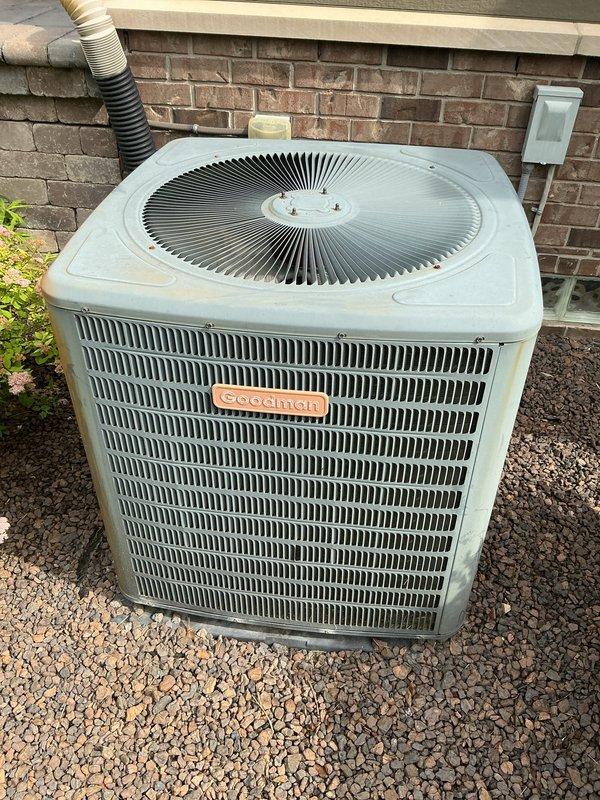 Completed comprehensive Gold AC inspection on an 11-year-old Goodman air conditioning system with basement-located air handler. Performed thorough multi-point evaluation of outdoor condenser unit, inspecting fan motor operation, electrical connections, refrigerant lines, and overall unit condition. Verified proper airflow through coil fins and checked for any signs of refrigerant leaks or component deterioration. Inspected basement air handler and coil assembly, examining drain line functionality, blower motor operation, and filter condition. Tested system operation and confirmed adequate cooling performance within acceptable parameters. Documented equipment condition with photographic evidence showing outdoor condenser unit positioned on gravel pad with proper clearances and basement mechanical room setup including dual water heaters and HVAC components. System operating as designed with no immediate service needs identified at time of inspection.