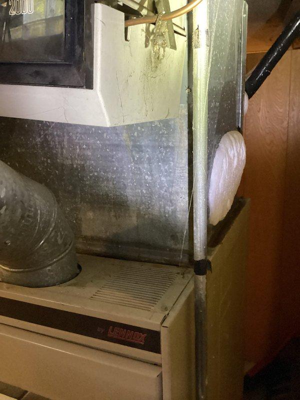 Conducted full system estimate for furnace and air conditioning replacement. Inspected existing Lennox furnace and air handler unit, noting significant dust accumulation on ductwork and plenum chamber, heavy condensation on air handler panel indicating active operation, and overall aging equipment condition. Documented current system configuration including ductwork connections, drain pan placement, and copper refrigerant lines. Photographed equipment to assess replacement requirements and provide comprehensive estimate for complete HVAC system upgrade.