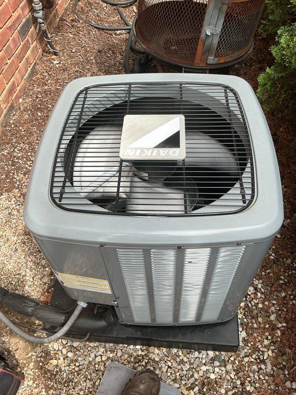 Completed comprehensive Gold AC inspection on a dual-zone residential system featuring two Daikin condensing units, approximately 4 years old, with indoor air handlers located in the basement. Performed thorough multi-point inspection of both outdoor condensing units including visual assessment of cabinet condition, refrigerant line connections, electrical conduit, mounting pads, and overall equipment operation. Both units found to be in proper working condition with adequate airflow through louvers, secure refrigerant line connections, and proper installation on gravel pad with vibration-dampening pads.