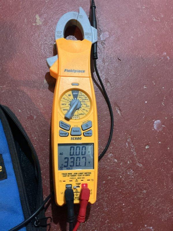 Responded to service call for 3-year-old cooling system in basement not cooling and blowing warm air. Upon arrival, performed diagnostic inspection of the unit and electrical system. Used Fieldpiece SC680 clamp meter to test electrical parameters including voltage, amperage, and system performance readings. Documented exterior electrical service and meter installation, as well as diagnostic measurements during troubleshooting process to identify root cause of cooling failure.