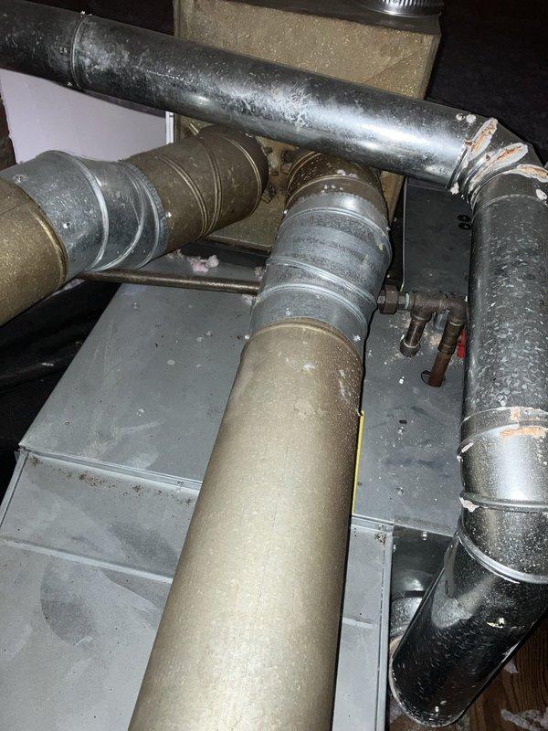 Conducted comprehensive assessment of residential cooling system for replacement estimate at small property under 1,500 square feet. Documented existing HVAC equipment configuration including air handler unit, supply ductwork with insulated flex runs, and metallic rigid ducts showing significant aging, dust accumulation, and deteriorated insulation covering. Measured equipment dimensions and photographed current installation conditions to provide accurate replacement specifications for new cooling system.