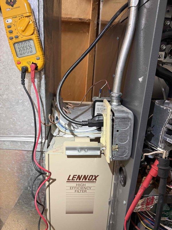 Performed diagnostic evaluation on 10+ year old cooling system located in basement to assess repair needs prior to potential replacement. Conducted electrical testing using digital multimeter on system components and utilized borescope camera to inspect internal evaporator coil condition and refrigerant lines. System evaluated with Lennox high efficiency filter unit in place, checking electrical connections, control mechanisms, and heat exchanger components for operational integrity and identifying any necessary repairs.