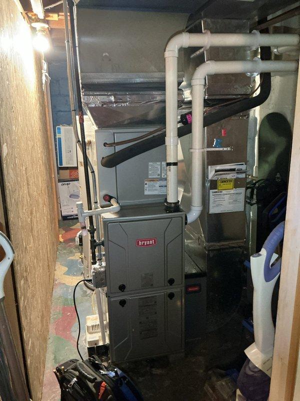 Responded to service call for 5-year-old AC system running but not cooling properly. Upon arrival, verified thermostat was calling for cooling and set to 72°F. Inspected Bryant furnace and air handler in basement mechanical room, confirming indoor blower operation and proper airflow through ductwork. Proceeded to exterior condensing unit to diagnose cooling failure. Found compressor not engaging due to failed start capacitor. Replaced defective capacitor with OEM equivalent, tested compressor operation, and verified proper amperage draw. Checked refrigerant pressures on both high and low sides, confirming adequate charge levels. System restored to full cooling capacity with temperature differential within manufacturer specifications. Documented equipment conditions with photos of thermostat and indoor HVAC components for service records.