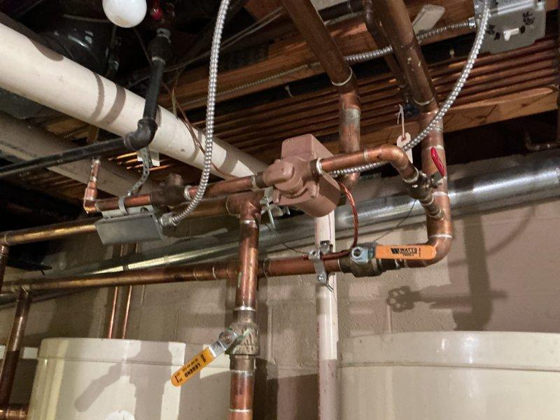 Service technician responded to customer concerns regarding inconsistent water temperature in multiple showers producing lukewarm water. Upon inspection of the mechanical room, evaluated the hot water distribution system including multiple water heaters and extensive copper piping network with circulation components. Documented the existing plumbing infrastructure and identified potential cartridge failures in shower valve assemblies as the likely cause of temperature issues. Recommended scheduling a licensed plumber to provide estimate for circulation pump evaluation and replacement of defective shower cartridges to restore proper hot water delivery throughout the residence.