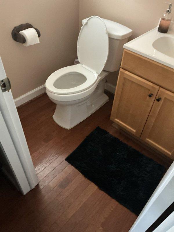 Responded to service call for toilet flushing issue causing water backup into washing machine sink. Upon arrival, inspected bathroom toilet and drainage system, then examined utility area plumbing connections near water heater. Diagnosed main drain line blockage affecting multiple fixtures due to shared drainage pathway between toilet and laundry sink. Cleared obstruction from drain line to restore proper flow and prevent cross-contamination between fixtures. Verified successful flush operation and confirmed washing machine sink no longer experiencing backup issues.
