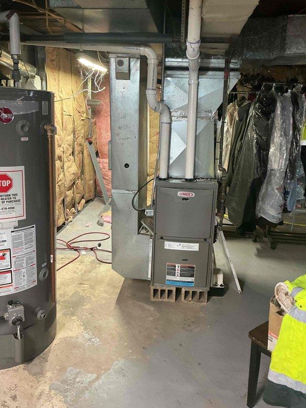Responded to service call for air conditioning system reported to be low on refrigerant. Inspected Lennox HVAC system with equipment located in basement and outdoor condenser unit positioned on concrete pad adjacent to building exterior. Performed system diagnostics including pressure testing, leak detection, and operational assessment of the 2017 model unit to determine refrigerant levels and identify any potential leaks in the system.