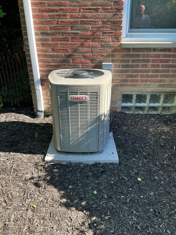 Completed comprehensive cooling system replacement estimate for a medium-sized residential property (1500-3000 sq.ft.) with basement unit location. Assessed existing Lennox outdoor condenser unit positioned on concrete pad against brick exterior wall, noting current equipment condition, electrical disconnect box, refrigerant line routing, and proper installation clearances. Recommended vertical upflow/downflow A/C coil configuration compatible with existing infrastructure and provided detailed replacement system specifications for complete cooling system upgrade.