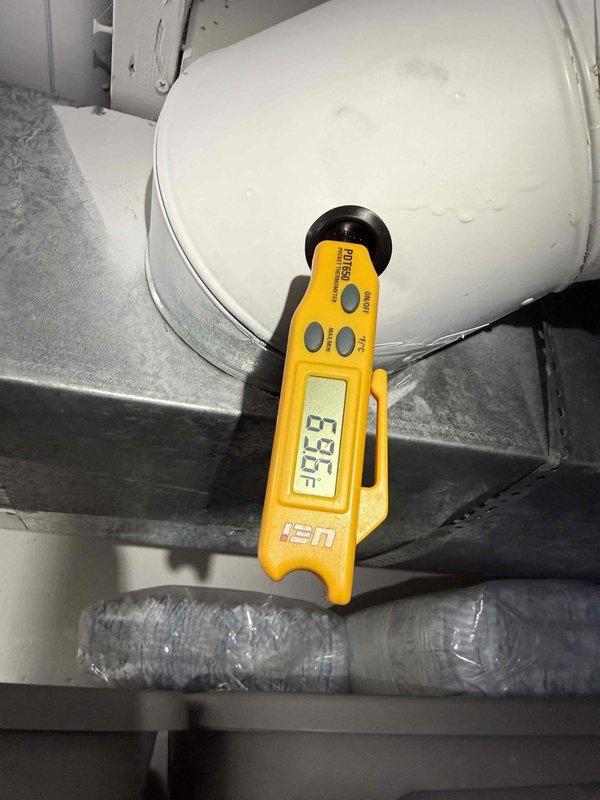 Responded to service call for 10+ year old air conditioning system making unusual noise during operation. Performed diagnostic inspection of outdoor condensing unit in backyard and indoor evaporator coil connected to basement furnace system. Utilized inspection camera to examine internal components, revealing significant rust and corrosion on metal surfaces within the system. Conducted temperature measurements on refrigerant lines and evaporator coil assembly, recording suction line temperature at 53.3°F. Documented condition of equipment showing signs of age-related deterioration and corrosion that may be contributing to operational noise. Provided findings and recommendations for addressing corroded components to restore quiet operation.