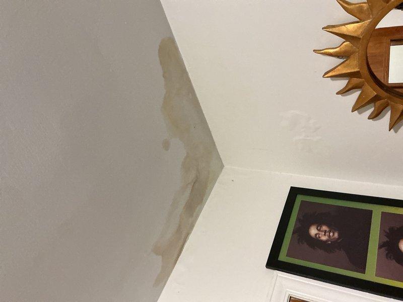 Responded to report of water leak from attic-mounted furnace occurring during laundry operation, with visible condensation damage on interior ceiling. Inspected 10-year-old HVAC system and evaporator coil assembly, identifying condensate drainage issue affecting air handler unit. Confirmed water staining on ceiling corner consistent with condensate overflow from furnace location above. Accessed internal components through air handler panel, examined evaporator coils, refrigerant lines, and condensate management system to diagnose source of moisture intrusion and recommend corrective action.