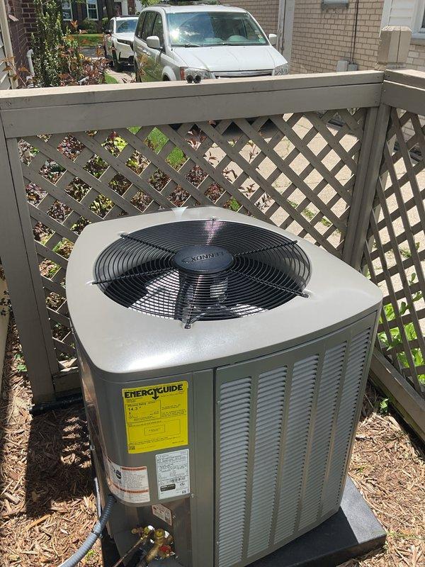 Completed installation of 3-ton air conditioning system with matching evaporator coil on left side of residence. Unit positioned on concrete pad against decorative lattice fence, with electrical disconnect box mounted on exterior wall and refrigerant lines properly insulated and routed through mulched side yard. All mechanical, electrical, and AC permits obtained and system reconnected per code requirements.