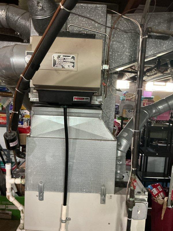 Performed estimate for complete air conditioning system replacement at residential property. Existing AC unit is approximately 20 years old and has reached end of serviceable life, located on exterior side of house. Inspected indoor air handler/furnace unit in basement mechanical room, noting copper refrigerant lines, metal ductwork connections with flexible and rigid sections, and standard PVC condensate drainage. Documented current system configuration including electrical connections and mounting arrangement. Photographed existing equipment to assess replacement requirements and provide visual reference for proposal. Recommended full system replacement due to age and efficiency considerations.