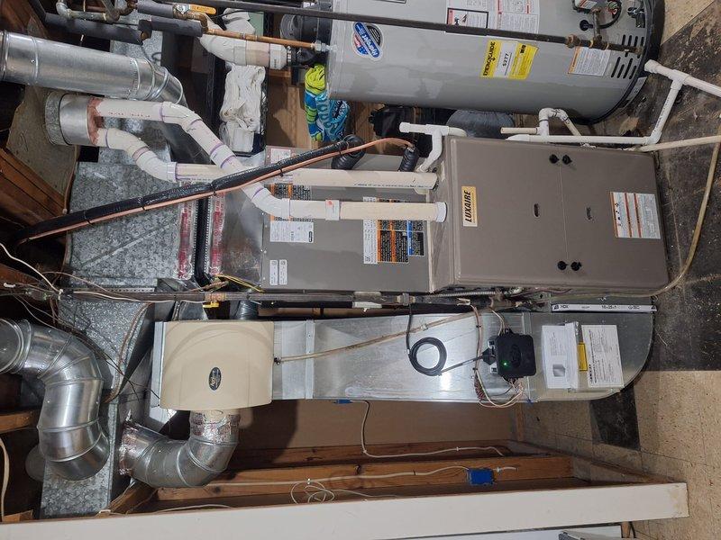 Successfully completed installation of a 2.5-ton Lennox air conditioning system with matching evaporator coil on the left side of the residence. The outdoor condenser unit was positioned on a platform pad with proper electrical connections, while the indoor air handler and coil were installed in the mechanical room with new ductwork, PVC condensate lines, and electrical conduit properly routed and secured.