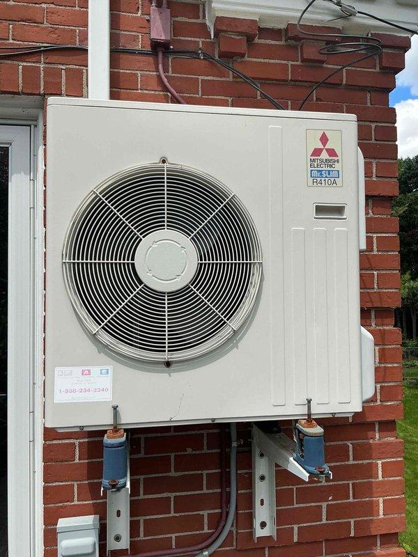 Completed comprehensive Gold AC inspection on 1-year-old Mitsubishi Electric mini-split system with outdoor condenser unit mounted on exterior brick wall and air handler located in basement. Performed thorough multi-point inspection including refrigerant line examination, electrical connection verification, condensate drain check, and operational testing of both indoor and outdoor units. System found to be operating within manufacturer specifications with all components functioning properly and no deficiencies noted.