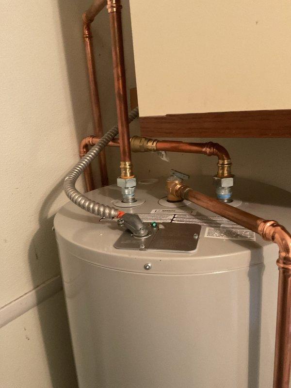 Completed installation of residential water heater in basement utility area. Connected hot and cold water supply lines using copper piping with proper dielectric unions and brass fittings to prevent galvanic corrosion. Installed flexible gas supply line with corrugated metallic connector to fuel source. All plumbing connections secured and tested for proper operation and leak-free performance.