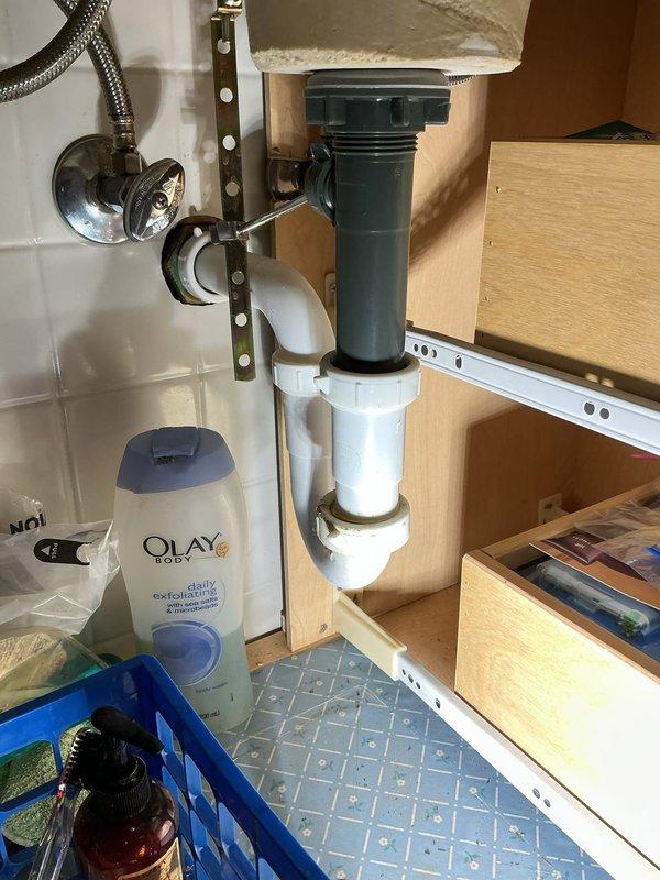 Responded to service call for leaking kitchen faucet. Upon inspection, examined supply lines, shut-off valves, and drain assemblies under both kitchen and bathroom sinks to identify source of leak. Inspected braided metal supply lines, chrome shut-off valves, P-trap assemblies, and all connection points for signs of water damage or active leaking. Documented existing plumbing configuration including PVC drain piping, compression fittings, and flexible supply lines. Verified proper operation of shut-off valves and assessed condition of all visible plumbing components to resolve reported leak issue.
